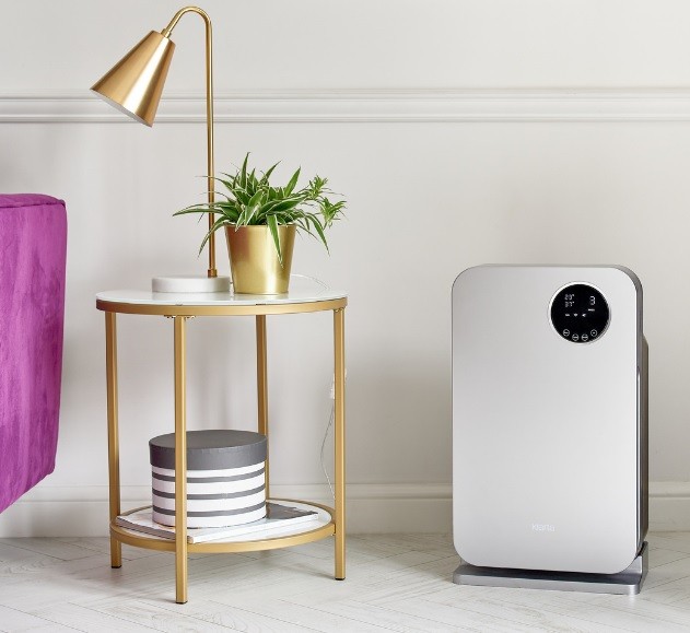 Luftreiniger Klarta Forste 4 arrangiert im Wohnzimmer neben einem Tisch