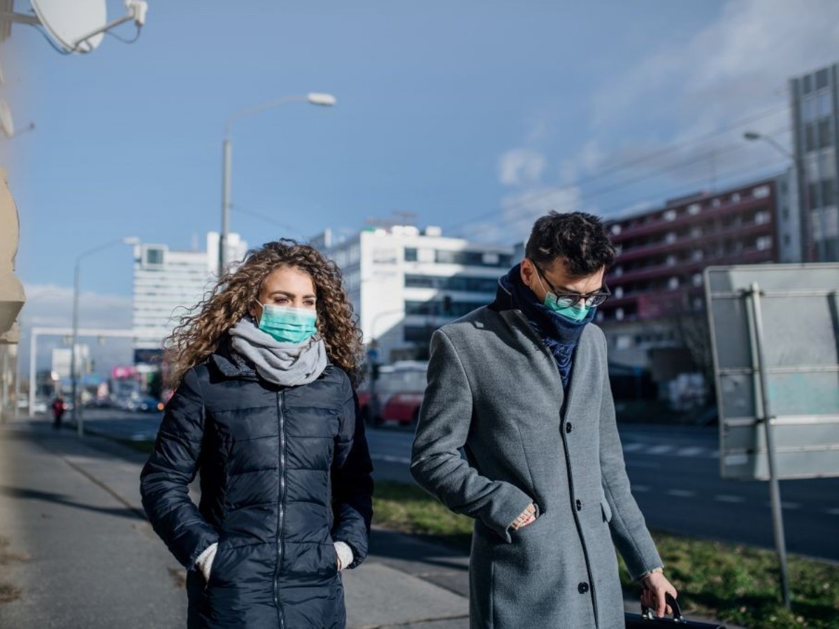 Frau und Mann mit Masken beim Spaziergang